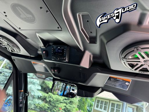 Interior view of a boat dashboard with speakers and a digital display.