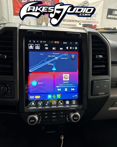 A large car dashboard touchscreen displaying a navigation map and media controls.