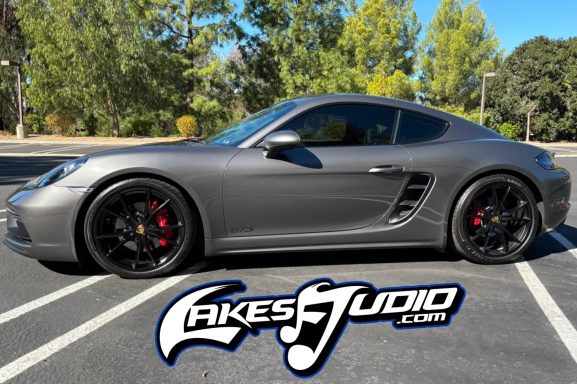 Side view of a sleek gray sports car parked on a sunny day.