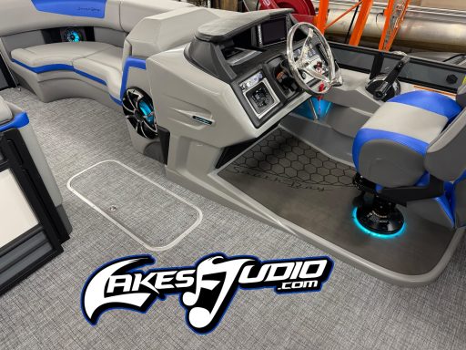 Interior of a modern boat with gray and blue seating and console, featuring glowing accents.